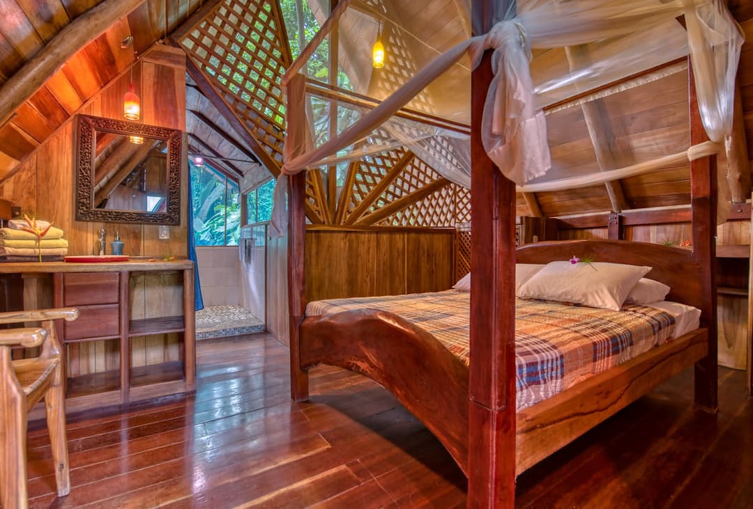 Upstairs loft bedroom — queen bed under the netted wall with private ensuite